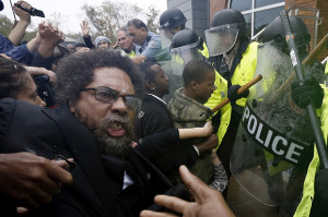 Activist Cornel West is knocked over during a scuffle with police during a protest at the Ferguson Police Department in Ferguson
